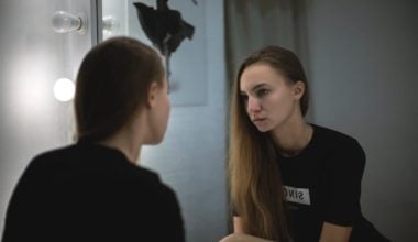 woman staring at herself in the mirror