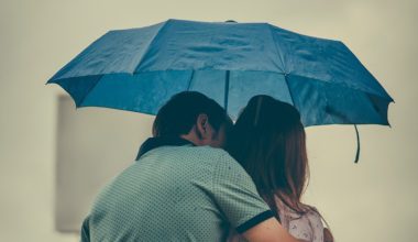 partners hugging under umbrella