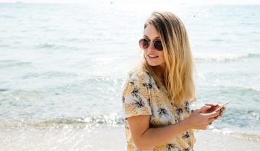 woman on the beach on her phone looking away