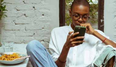 woman scrolling through phone at restaurant
