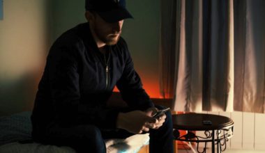 Man in dark room looking at his phone