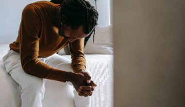 man sitting on bed with head down