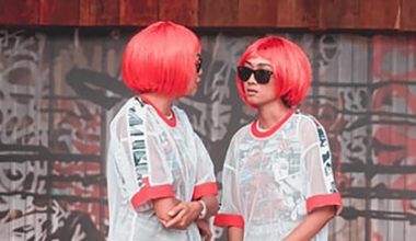 two young girls with matching wigs looking at each other