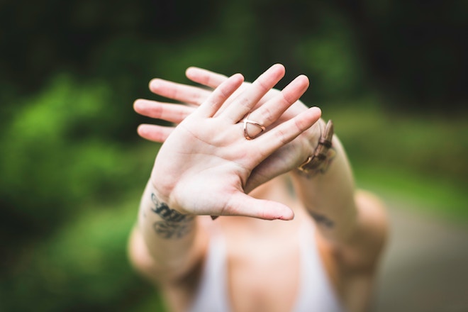 A woman crosses her hands in front of the camera