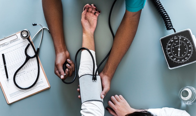 A doctor checks a patient's blood pressure, surrounded by medical implements