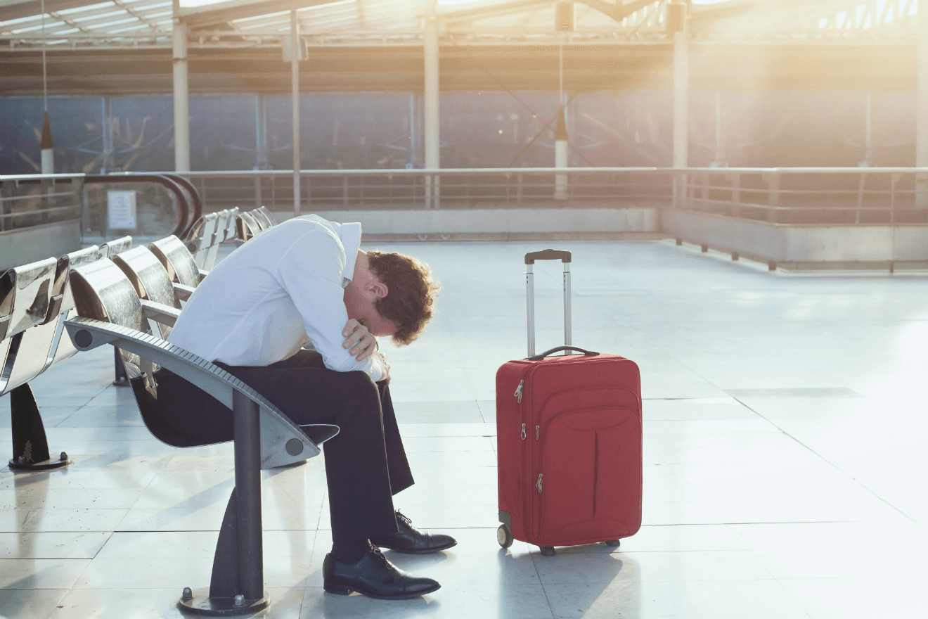 depressed man airport red suitcase