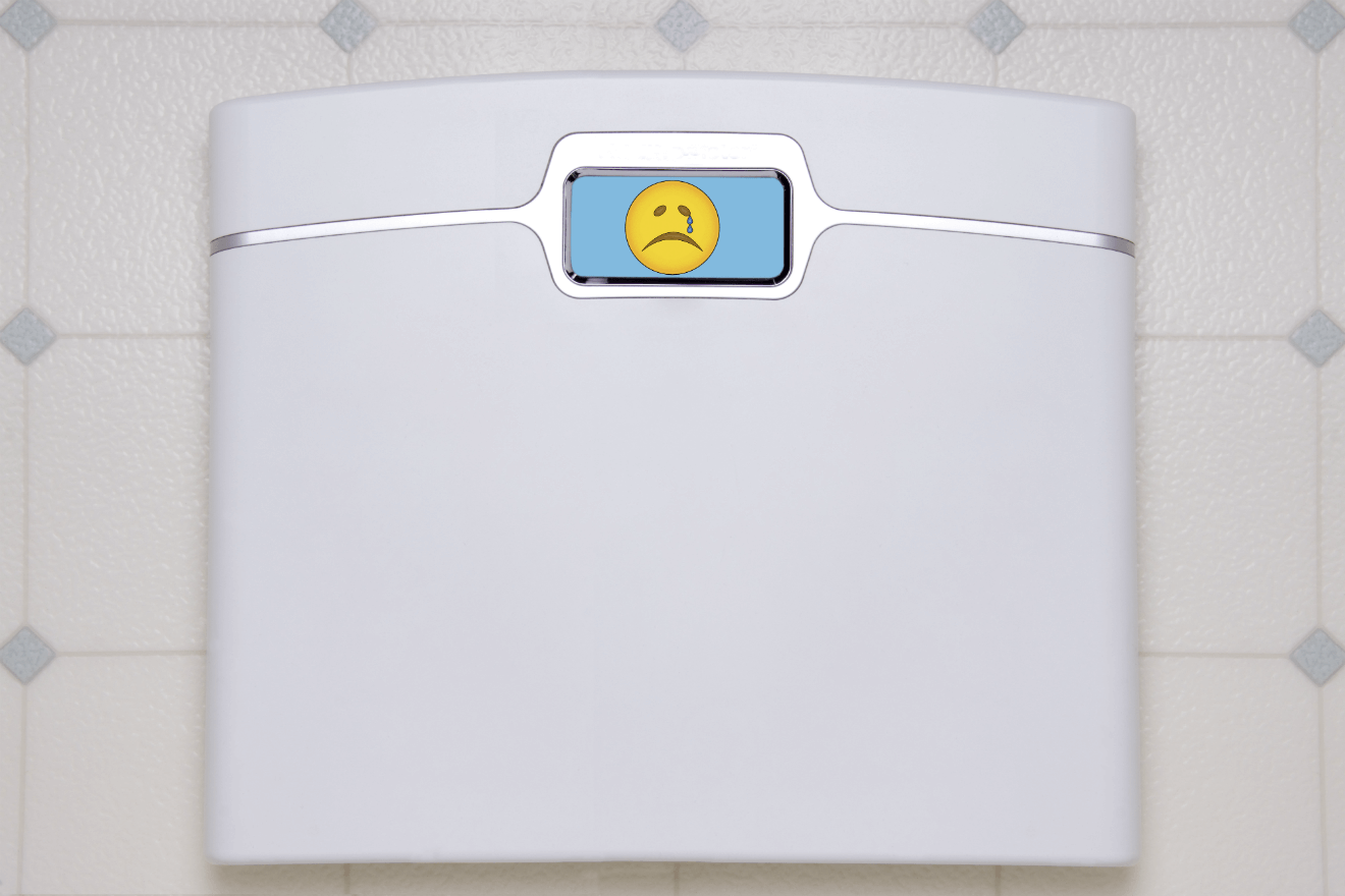 white scale in bathroom with sad face emoji on digital display