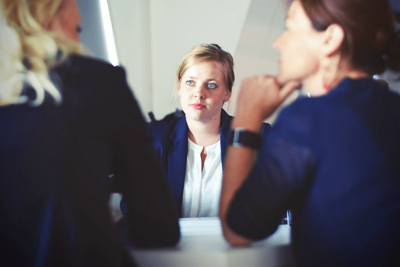anxious woman at conference table with co-workers